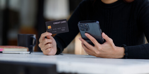 Woman hand using a credit card and mobile smartphone, online payment, banking, and online shopping 