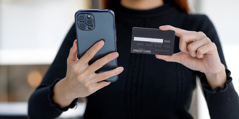 Woman hand using a credit card and mobile smartphone, online payment, banking, and online shopping 