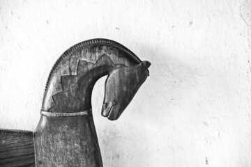 Wooden horse against white wall