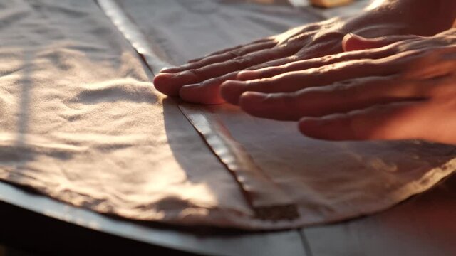 Tailoring individually to order in the studio. The tailor takes measurements with a centimeter for cutting fabric.