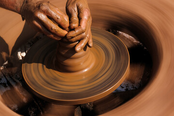 Potter modeling of clay on a potter's wheel In the pottery shop, Maharashtra, India.