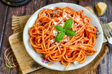 Spaghetti  bolognese .Italian home made meal Fresh  bucatini pasta with tomato sauce, basil, herbs ,parmesan cheese ,fresh cherry tomatoes and parsley on wooden background. Kitchen Poster 