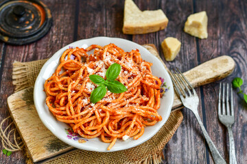 Spaghetti  bolognese .Italian home made meal Fresh  bucatini pasta with tomato sauce, basil, herbs ,parmesan cheese ,fresh cherry tomatoes and parsley on wooden background. Kitchen Poster 
