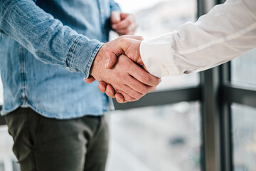 Close up shot of teamwork handshake in the office businessman entrepreneur freelancer shaking hands...