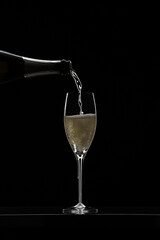 Pouring champagne in glass graphically presented in studio setting