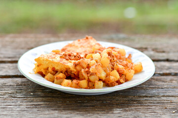  Potato and minced meat  Casserole  with   parmesan cheese and garlic on wooden rustic bakcground.  Bulgarian moussaka