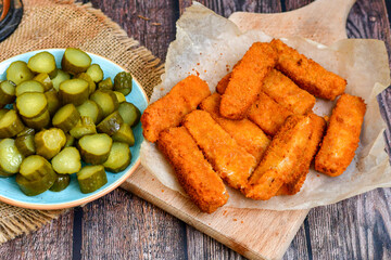 Close up of   Crispy breaded  deep fried fish fingers with breadcrumbs served  with remoulade sauce and  lemon Cod Fish Nuggets on rustic wood table background