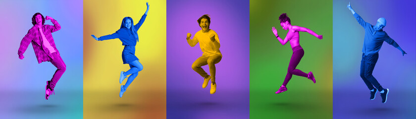 Fototapeta na wymiar Excited millennial diverse people jumping and shouting in joy over colorful neon studio backgrounds, panorama