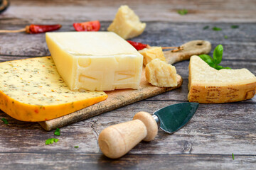  Set of different kinds ot delicious   Italian hard  cheeses,  cheese knives  and walnuts on wooden cheese board.Parmesan. Top view.