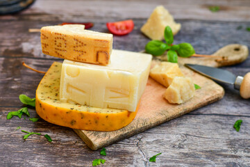  Set of different kinds ot delicious   Italian hard  cheeses,  cheese knives  and walnuts on wooden cheese board.Parmesan. Top view.