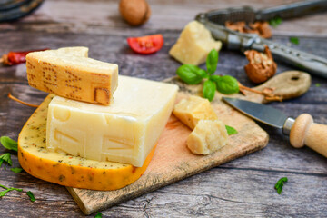  Set of different kinds ot delicious   Italian hard  cheeses,  cheese knives  and walnuts on wooden cheese board.Parmesan. Top view.
