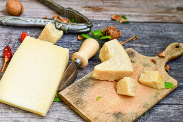  Set of different kinds ot delicious   Italian hard  cheeses,  cheese knives  and walnuts on wooden cheese board.Parmesan. Top view.