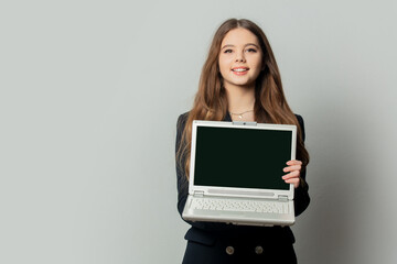Beautiful girl in black jacket with laptop computer on white background