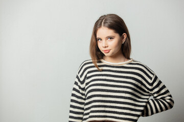 Fototapeta premium Beautiful girl in striped sweater on white background