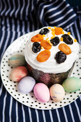 Easter eggs and Easter cake lie on a plate lying on a striped blue apron. Easter religious holiday concept.