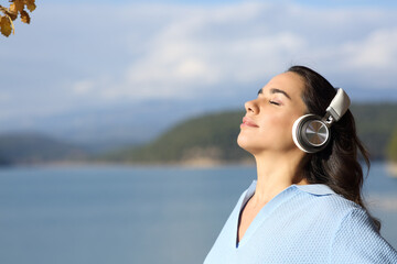 Woman wearing headphones meditating in a lake