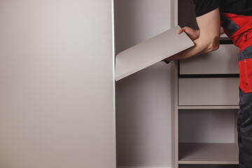 Furniture assembler assembles modern sliding door wardrobe
