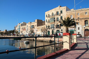 flat buildings and cove in kalkara in malta 