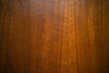 Photo of a mahogany texture covered with glossy varnish. Wooden panel from furniture.