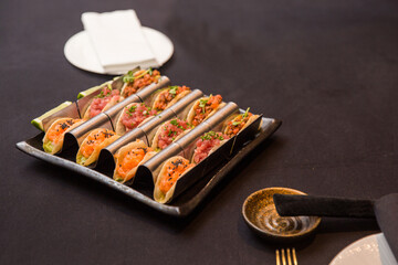 Sushi and rolls on a plate close-up on a dark background.