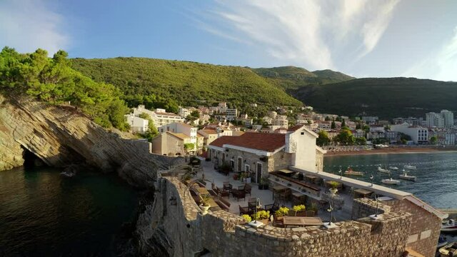PETROVAC, MONTENEGRO - SEPTEMBER 19, 2021: Scenic view on the town, shore, and restaurant terrace in the morning in Petrovac, Montenegro. 4K, Binaural Audio. Ultra-wide