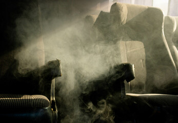 Interior of a bus with thick smoke running through the seats and spaces with direct light from the...
