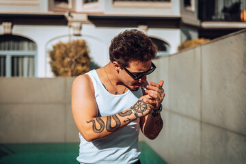 Close-up of a tattooed guy with sunglasses smoking