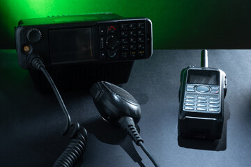 Closeup of pair of mobile two-way radios for Amateur radio operators against dark background.