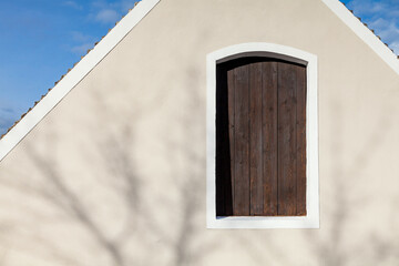 Haus mit einer beigen Fassade, einer alten Holztür mit weißen Rändern