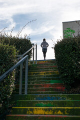 Woman climbing colorful stairs