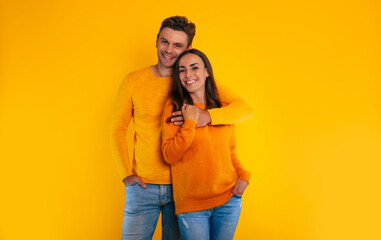 My darling! Happy young couple in love is celebrating Valentine’s Day, hugging each other and laughing together while they isolated on yellow background