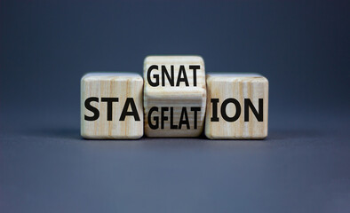 Stagflation or stagnation symbol. Businessman turns cubes, changes the word stagnation to...