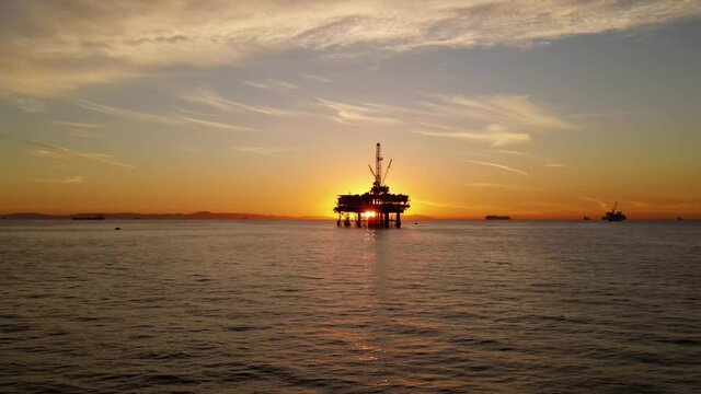 Aerial shot of an offshore oil platform at sunset