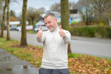 Middle-aged man giving a double thumbs up if success and support