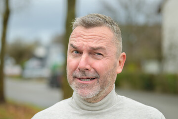 Middle-aged man winking at camera with a cheesy grin