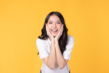Image of feeling excited, shock, surprise and happy. Young asian woman standing on yellow...