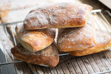 Batch of ciabatta bread on a cooling rack.