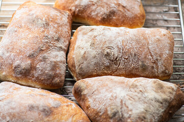 Batch of ciabatta bread on a cooling rack.