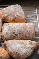 Batch of ciabatta bread on a cooling rack.