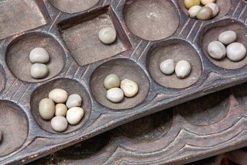 Rolgordijnen Boa Mancala tradition African Board Game With natural baobab tree seeds Balls. Stone Town Zanzibar, Tanzania. Mancala is a game which is very popular in Africa and Arabs © Natalia