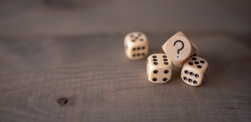Some game dice with question mark on wooden background