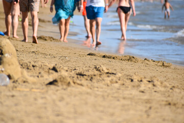 people walk on  seashore on  sand. tourists at sea are walking along the coastline. tourist holiday season in  tropics