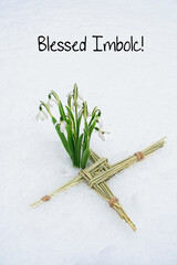 Blessed Imbolc greeting card. ireland amulet from straw and snowdrops flowers  in snow natural...
