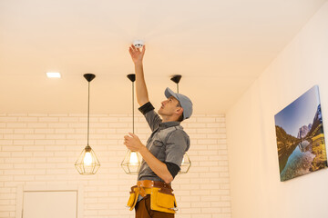 Handyman installing a smoke detector on the ceiling