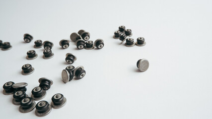 Repair of winter studded tires. Repaired spikes scattered on a white background. Replaced lost car tire spikes.