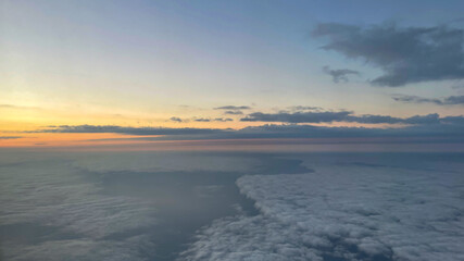 View from airplane above clouds and city