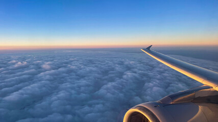 View from airplane above clouds and city