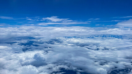 View from airplane above clouds and city