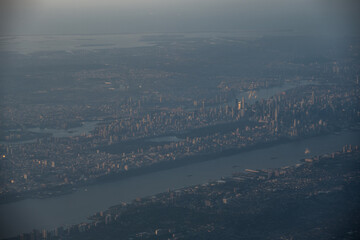 View from airplane above clouds and city