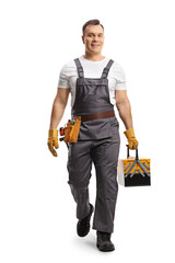 Full length portrait of a repairman in a uniform carrying a tool box and walking towards camera